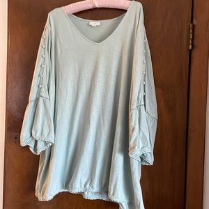 Light teal tunic with special details on sleeves.